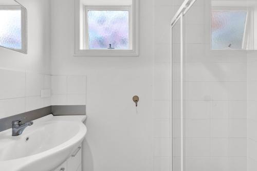a white bathroom with a sink and a shower at Windsor Green Hotel in Melbourne