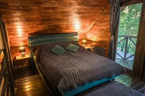 a bed in a room with a wooden wall at Mátra Boutique in Mátraszentimre