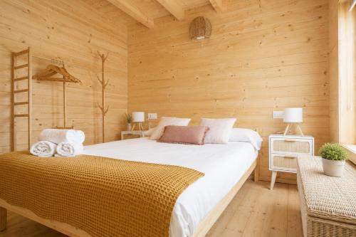 a bedroom with a bed in a wooden room at Cabanas Allariz in Allariz