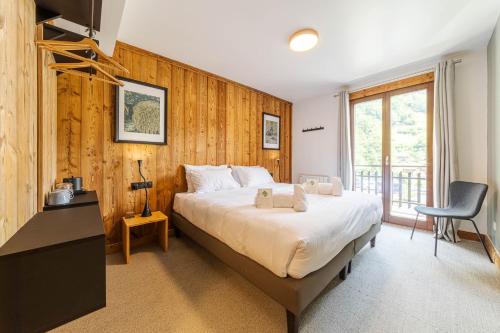 a bedroom with a bed and a desk and a chair at Hotel Du Lac in Montriond
