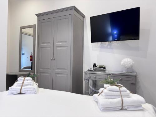a bedroom with a bed with a tv on the wall at Ognissanti Rooms in Acireale