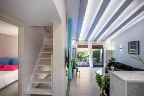 a living room with a staircase leading to a bedroom at NeonChic Jacuzzi and Pool Villa in Sani Beach