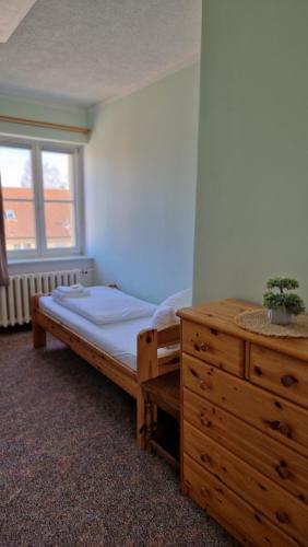a bedroom with a bed and a dresser and a window at Gästehaus Wilsickow in Lübbenow