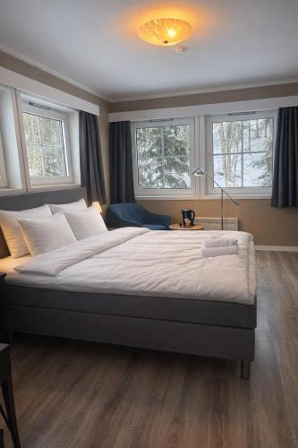 a bedroom with a large bed in a room with windows at Storebaug Motell in Moss