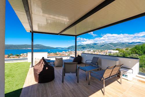 a patio with a view of the water and mountains at Villa Aquilla in Tivat