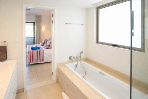a bathroom with a bath tub in a room at Manta Cove by Blue Zebra Holidays in Rivière Noire