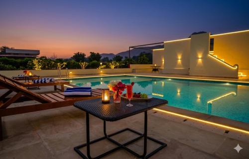 a villa with a swimming pool and a table at Guldaar Sariska - A Luxury Forest Retreat in Tehla