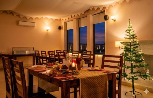 a dining room with a table and a christmas tree at Guldaar Sariska - A Luxury Forest Retreat in Tehla