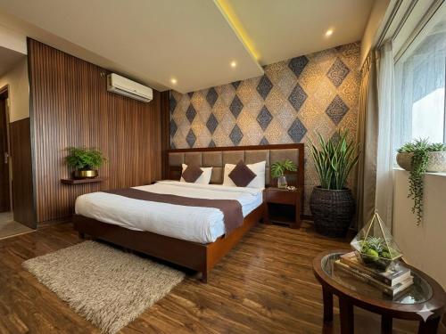 a bedroom with a large bed and a table at Hotel Royal Serena in Ambāla