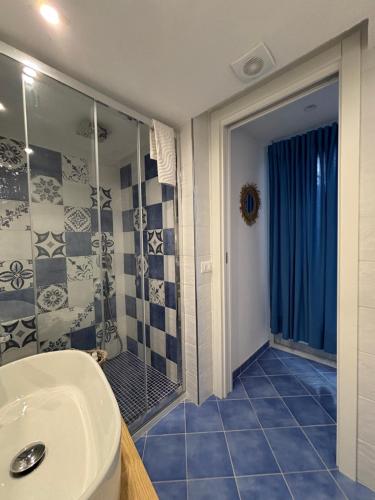 a bathroom with a shower and a white sink at Fefalù House in Ischia Town