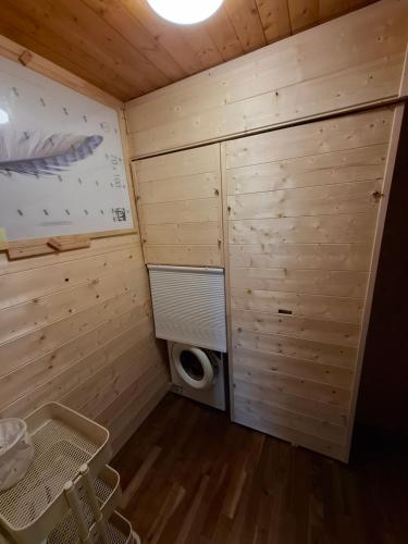 a small room with a washing machine in a wooden room at Chalet AS des Pics in Nendaz