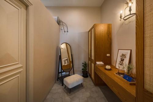 a bathroom with a vanity and a mirror and a chair at SaffronStays RiverSong Britona in Ribandar
