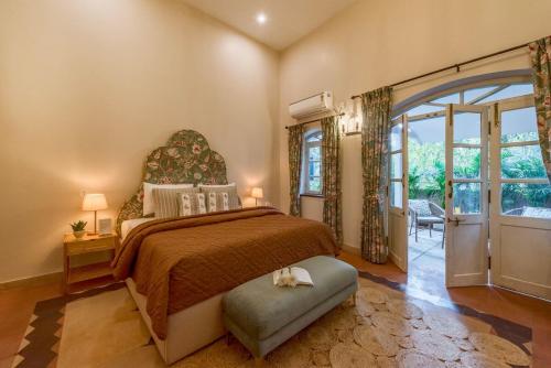 a bedroom with a large bed and a large window at SaffronStays RiverSong Britona in Ribandar