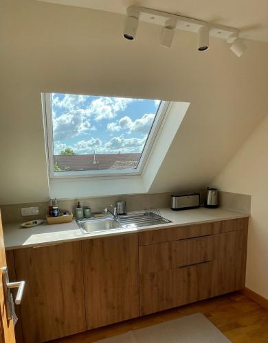 a kitchen with a sink and a window at Maison Maragelie in Westhoffen