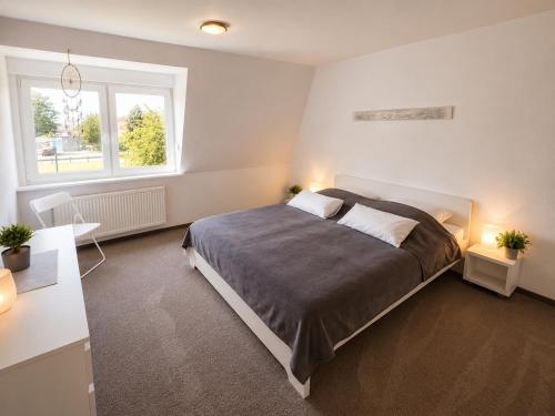 a bedroom with a large bed and two windows at Rauszeit-Balje in Balje