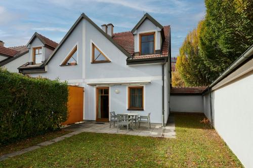 ein weißes Haus mit einem Tisch im Hof in der Unterkunft DAS BURGENNEST Chalet 6 - Familienchalet für 5 mit privatem Bademantelgang zur Therme in Lutzmannsburg