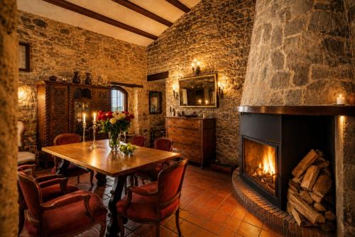a dining room with a fireplace and a table and chairs at Fortaleza Medieval La Manyosa in Granera