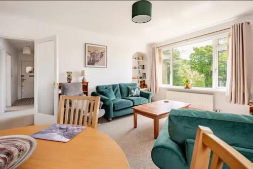 a living room with a green couch and a table at The Waterside Apartment 6 in Largs