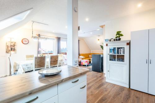 a kitchen with white cabinets and a wooden counter top at Ferienwohnung Frankenblick in Frankenau