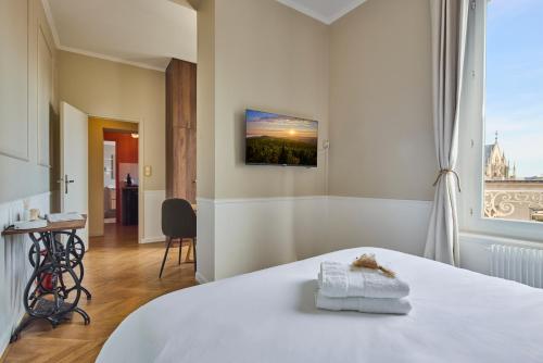 a bedroom with a white bed and a window at Haussmannien calme hyper-centre in Troyes