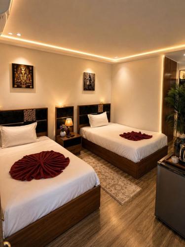 a hotel room with two beds with red pillows on them at Anubis Pyramids View Inn in Cairo