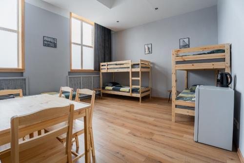 ein Zimmer mit Tisch, Stühlen und Etagenbetten in der Unterkunft Purva3 in Valmiera