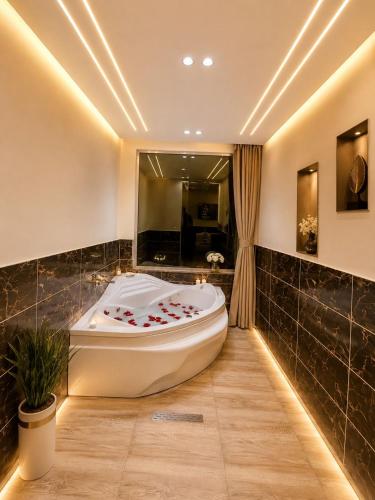 a bath tub in a bathroom with a large mirror at Anubis Pyramids View Inn in Cairo