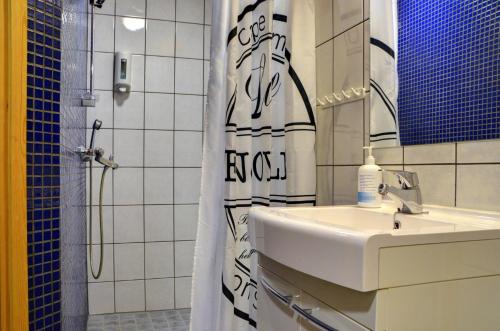 a bathroom with a sink and a shower curtain at Alppitalo 2 as 1 in Tahkovuori