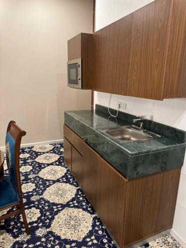 a kitchen with a sink and a microwave at Vista Hotel Haql in Al Humaizah
