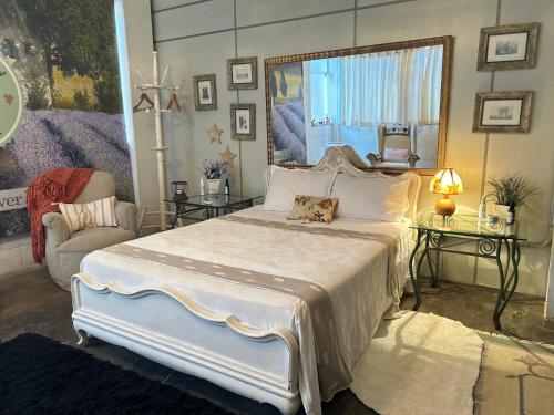 a bedroom with a large white bed and a chair at Body & Mind Beautiful - Suites Elegantes e Charmosas in Franca