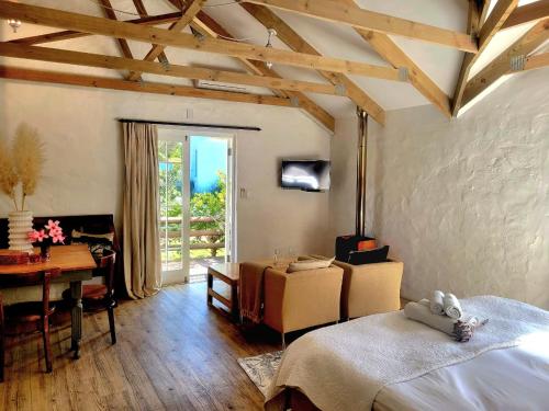 a bedroom with a bed and a table and a desk at De Molen Guest House in Somerset West