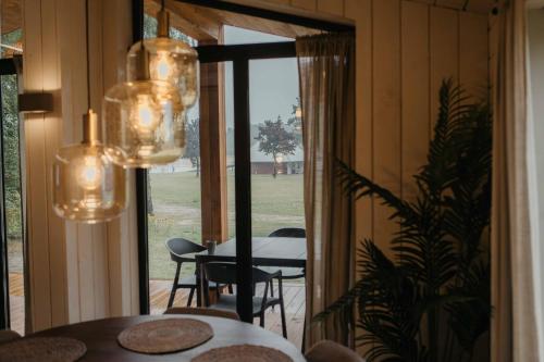 a dining room with a table and chairs and chandeliers at Resort Wilsumer Berge in Wilsum