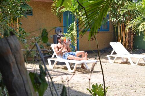 a man laying in a chair on the beach at Raj Mahal Inn in Wadduwa