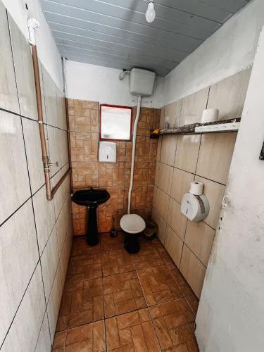 a small bathroom with a toilet and a sink at Camping Mairiporã in Mairiporã