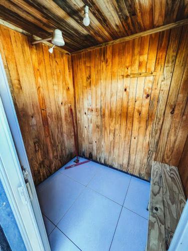a small room with wooden walls and a ceiling at Camping Mairiporã in Mairiporã