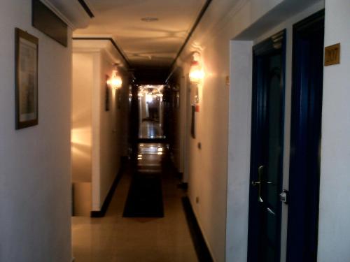 a long hallway with white walls and a ceiling at Hotel VillaPaloma in La Virgen del Camino
