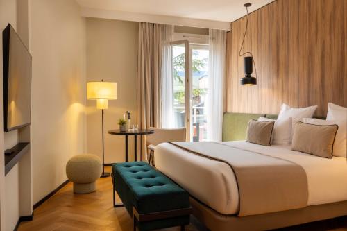 a hotel room with a large bed and a window at Le Richebourg Hôtel, Restaurant & Spa in Vosne-Romanée