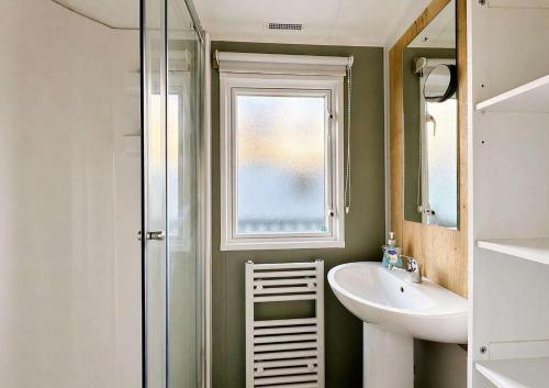 a bathroom with a sink and a mirror at Kestrel Court 16 in Scratby