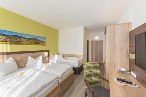 a hotel room with two beds and a chair at Sleepin Premium Motel Loosdorf in Loosdorf
