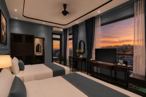 a bedroom with two beds and a television with a view at Lumina Premium- HT Boutique 2 - Đống Đa in Da Lat