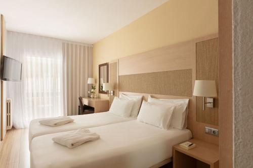 a hotel room with a large bed with white pillows at Augusta Club & Spa - Adults Only in Lloret de Mar