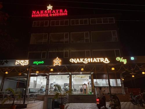 a restaurant with a sign on the front of it at night at Nakshatra Boarding and Lodging in Mangalore International