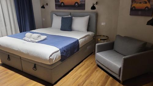 a hotel room with a bed and a chair at Sette Vele Rooms in Trieste