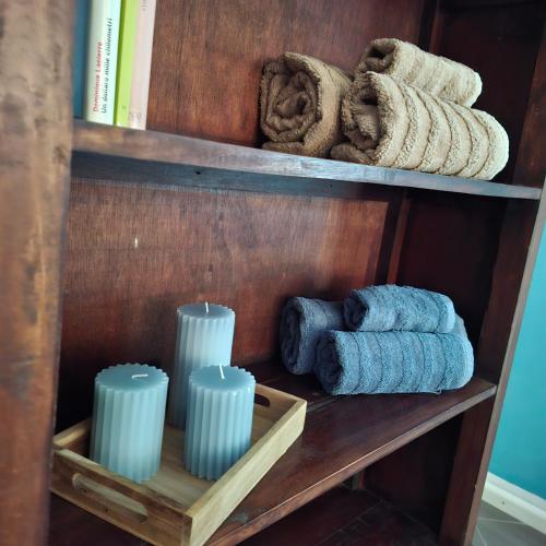 a wooden shelf with towels and candles on it at Quasi in Cattedrale, nel cuore storico di Asti in Asti