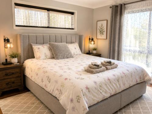 a bedroom with a bed with two towels on it at Sunlit Lodge in Rochedale South