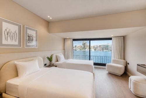 a hotel room with two beds and a large window at The Nile Residence in Cairo