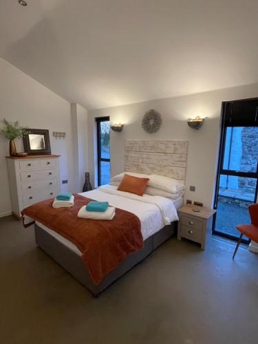 a bedroom with a large bed and a window at Umber, Gallery Cottages, Devon in West Putford