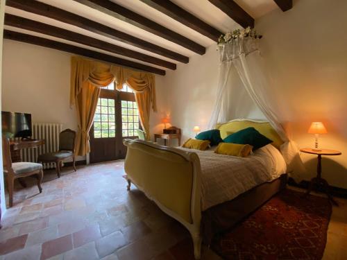 a bedroom with a bed with a mosquito net at Domaine Lainault - Chambre Jasnières in Lhomme
