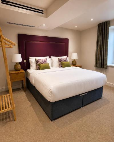 a bedroom with a large bed and two night stands at The Old Malthouse Caerleon in Caerleon