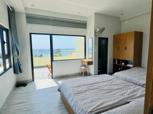 a bedroom with a bed and a view of the ocean at Khách Sạn View Biển - Homestay Sân Vườn - QUANG VINH Đảo Lý Sơn -Vị Trí Trung Tâm Đảo - Cạnh Bến cảng và Quảng trường in Ly Son